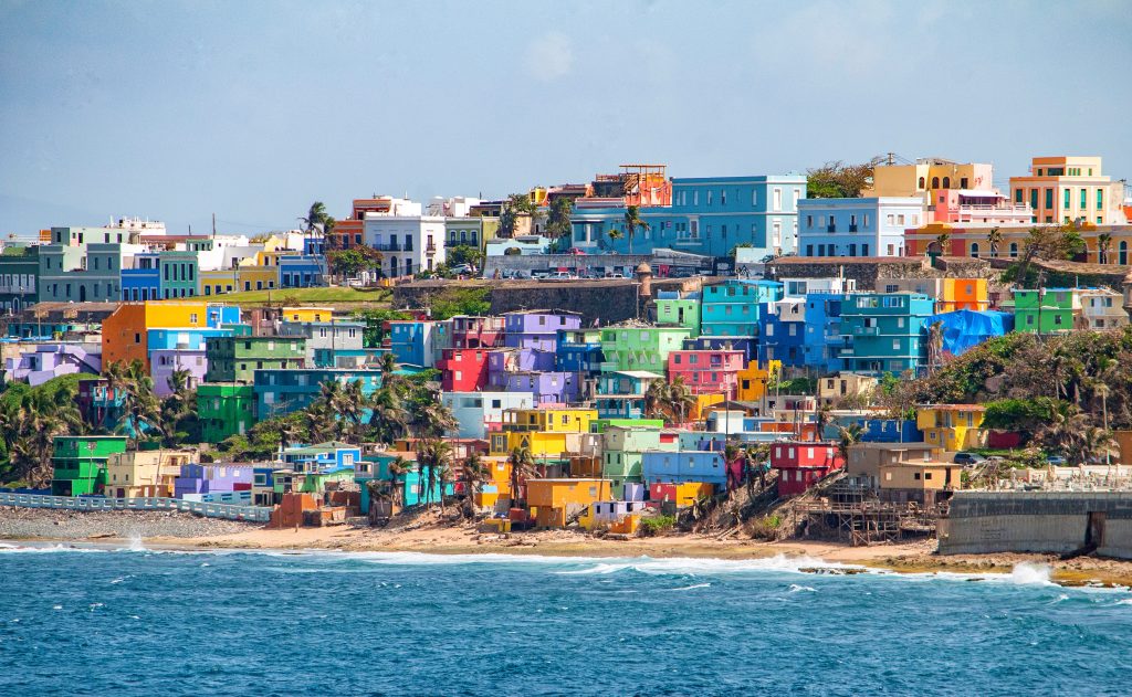 Colorful houses line the hillside over looking the beach in San Juan, Puerto Rico, one of the many benefits The Benefits of Moving to Puerto Rico
